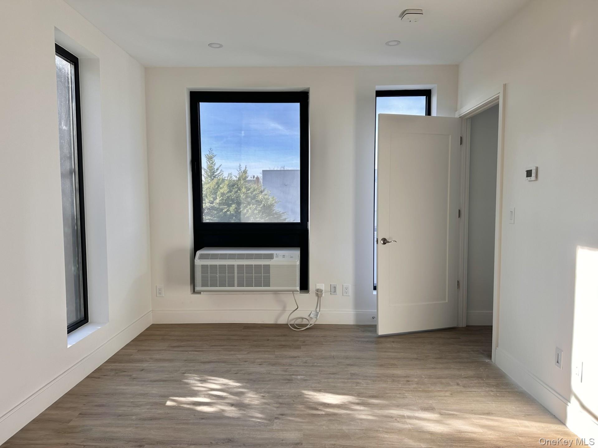 362 West Merrick Road, Unit 207 Valley Stream, NY 11580 - Photo 5 of 7 Spare room featuring light wood finished floors and cooling unit