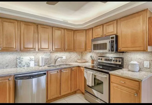 a kitchen with stainless steel appliances granite countertop a sink stove and microwave