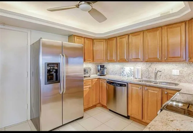 a kitchen with stainless steel appliances granite countertop a refrigerator a sink and dishwasher