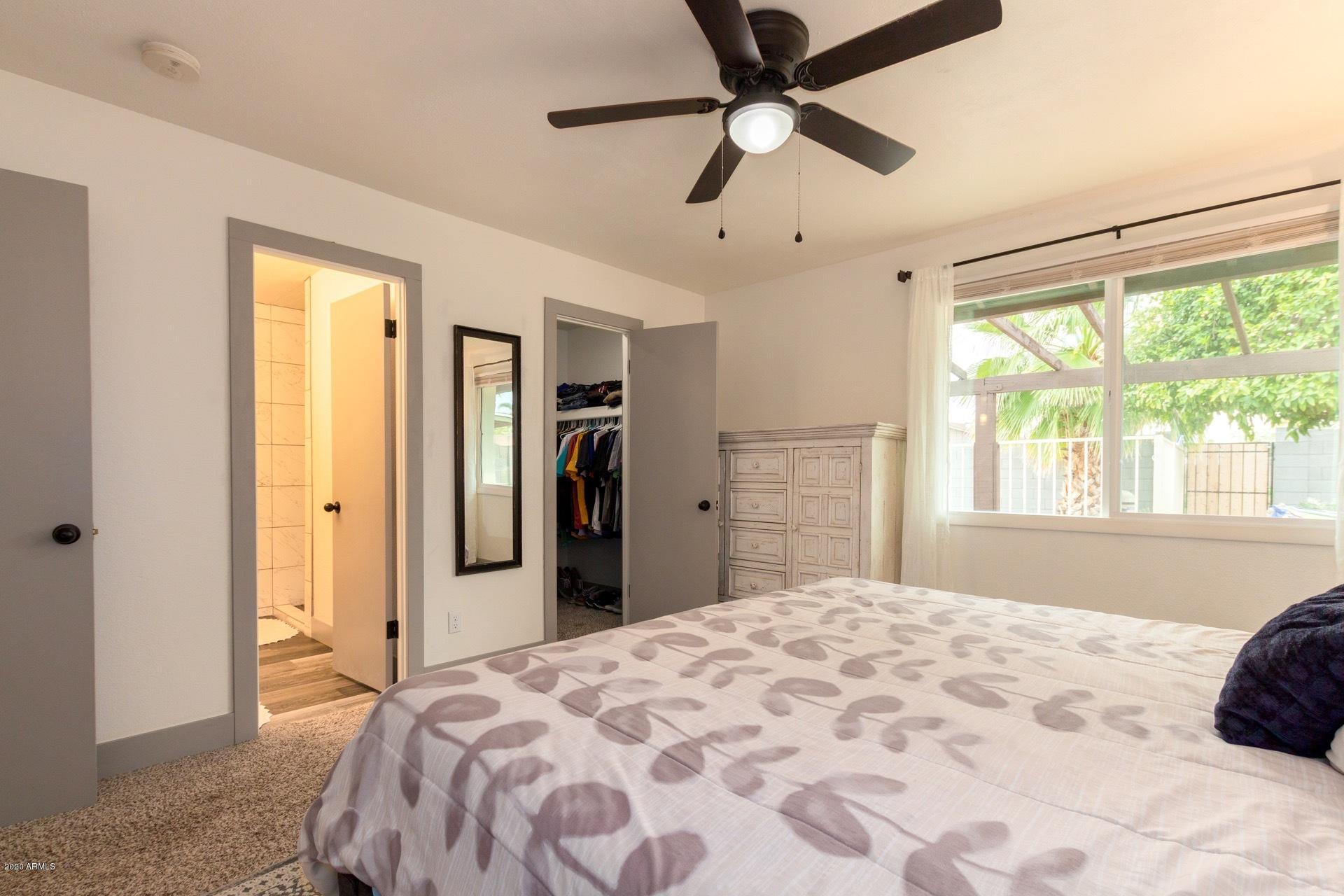 2439 East Riviera Drive Tempe, AZ 85282 - Photo 20 of 40 a bedroom with a large bed and a chandelier