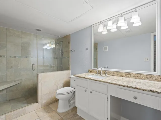 a bathroom with a granite countertop sink mirror toilet and bathtub