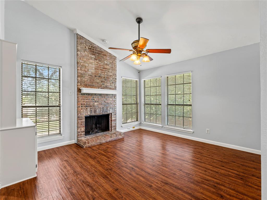 3101 Townbluff Drive, Unit 1024 Plano, TX 75075 - Photo 7 of 19 a view of an empty room with wooden floor fireplace and a window