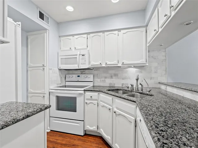 a kitchen with stainless steel appliances granite countertop a sink stove and cabinets