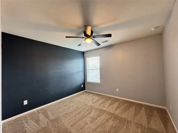 a view of a room with a ceiling fan and window