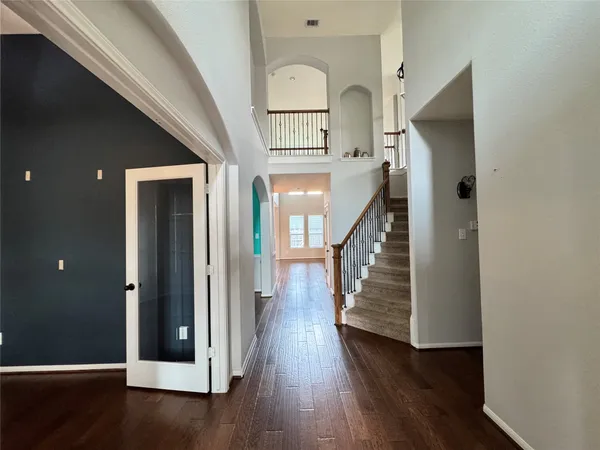a view of a hallway with wooden floor and staircase