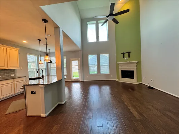 a view of a kitchen center island with wooden floor and staircase