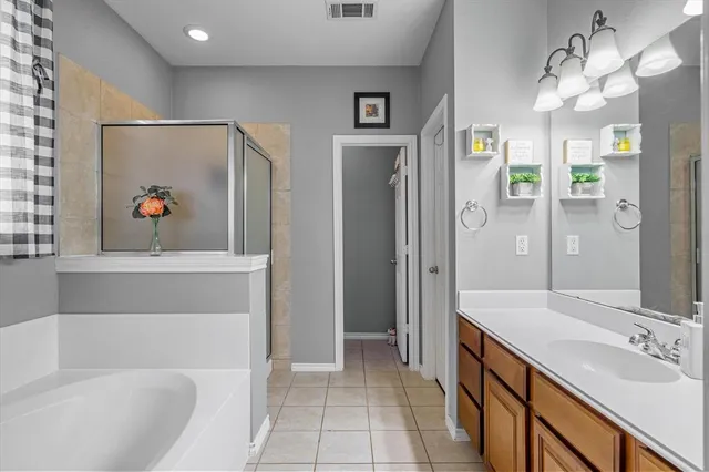 a bathroom with a tub a sink and glass door