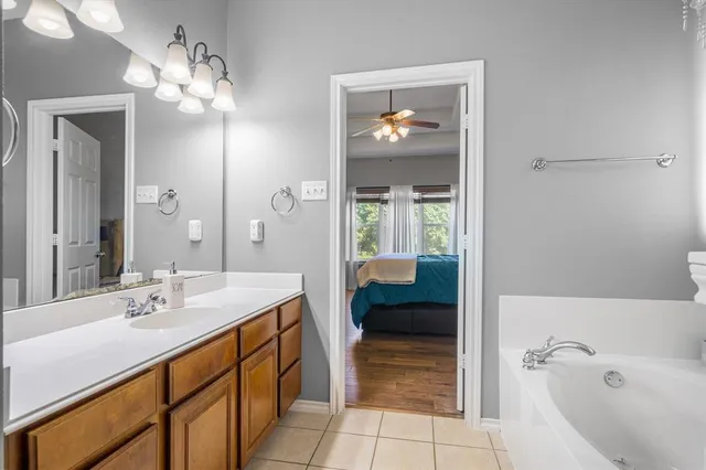 a spacious bathroom with a granite countertop sink a toilet and a mirror