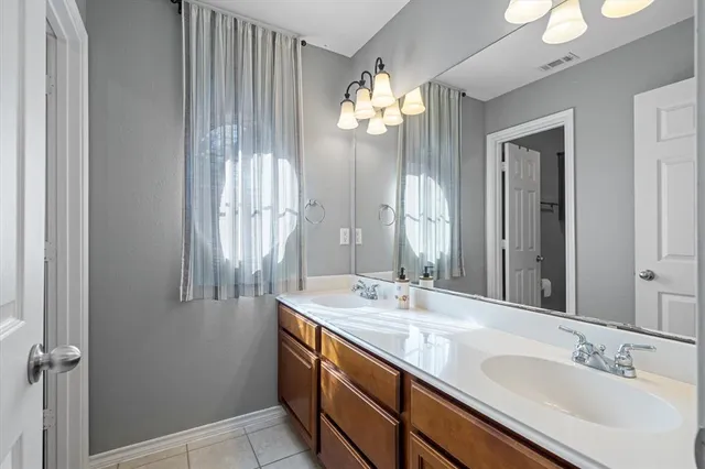 a bathroom with a double vanity sink and a mirror