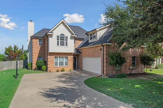 a front view of a house with a garden and trees