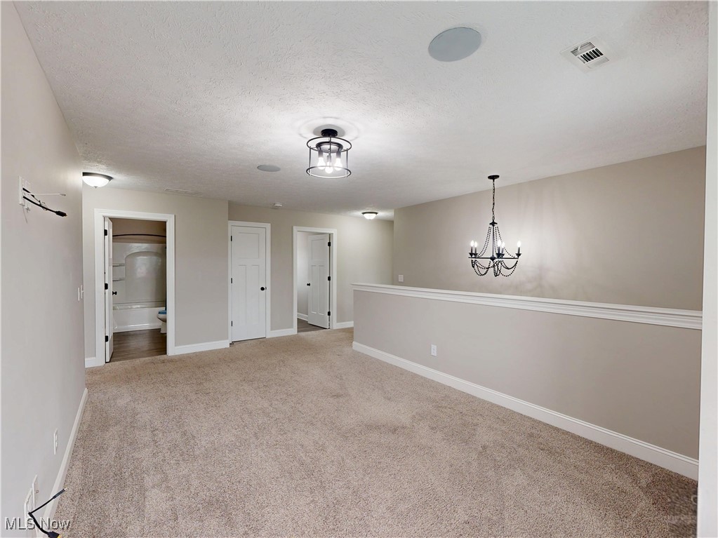 37328 Sandy Ridge Drive North Ridgeville, OH 44039 - Photo 28 of 39 Carpeted empty room featuring a textured ceiling, baseboards, and a chandelier