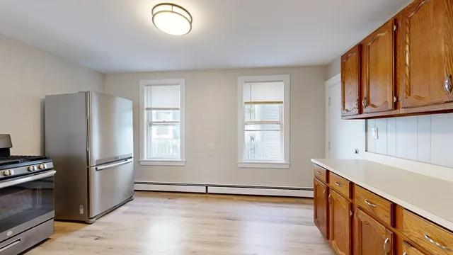 a view of a kitchen with wooden floor and electronic appliances