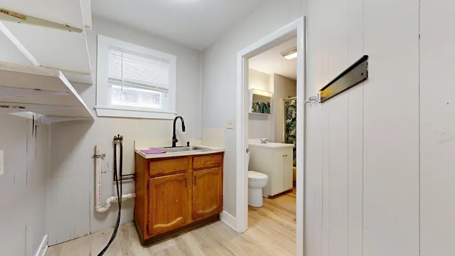 a bathroom with a sink a toilet and a window