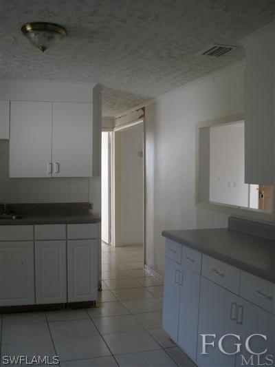 1112 Patterson Road Cape Coral, FL 33909 - Photo 4 of 7 a kitchen with a sink and cabinets