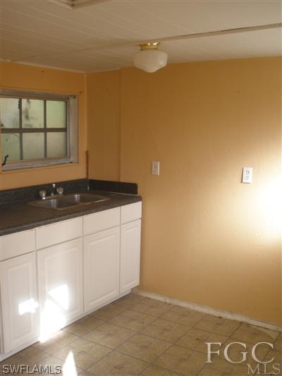 1112 Patterson Road Cape Coral, FL 33909 - Photo 5 of 7 a kitchen with a sink and cabinets