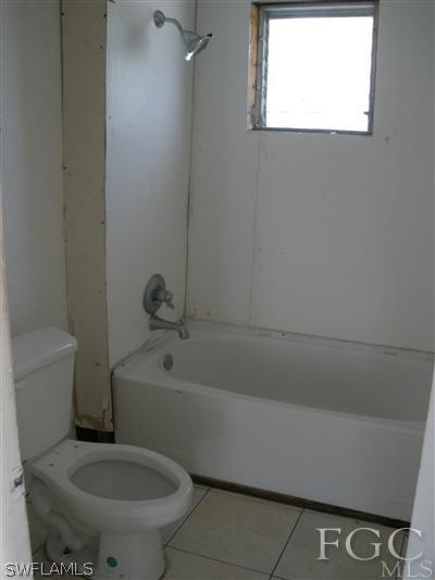 1112 Patterson Road Cape Coral, FL 33909 - Photo 7 of 7 a bathroom with a toilet and a bathtub