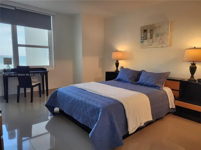 a bedroom with a bed and table chair