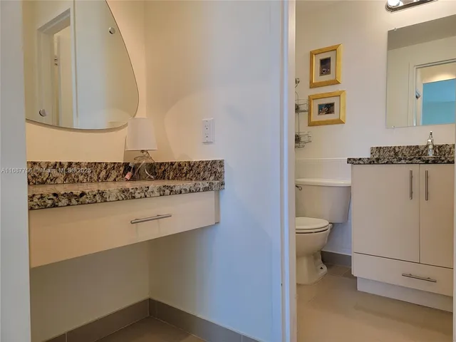 a bathroom with a sink a toilet and mirror