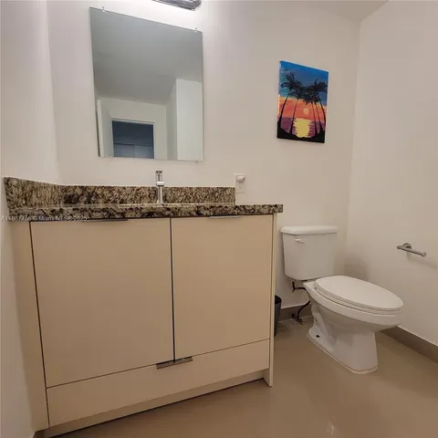 a bathroom with a toilet a sink and mirror