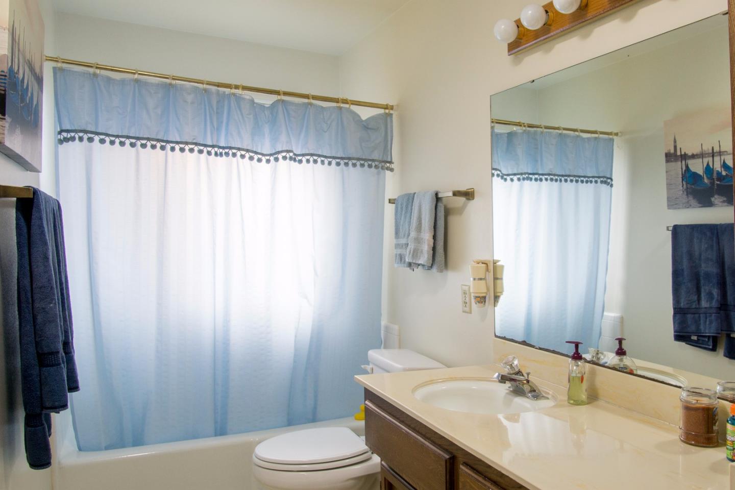 1626 Atherton Way Salinas, CA 93906 - Photo 16 of 23 a bathroom with a sink a toilet and shower curtain