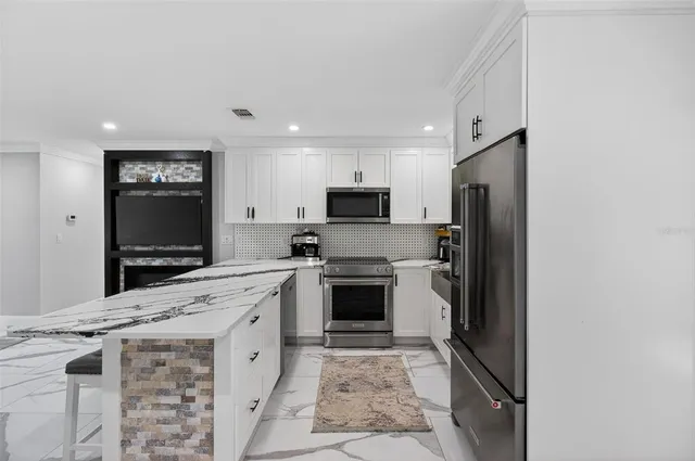 a kitchen with stainless steel appliances granite countertop a stove top oven a sink and dishwasher a refrigerator with wooden floor