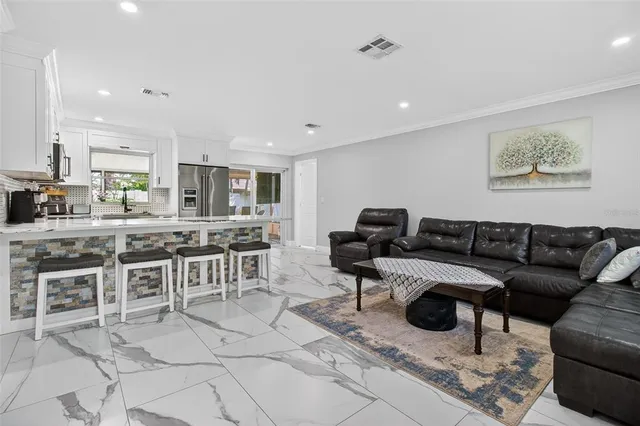a living room with furniture a kitchen view and a dining table