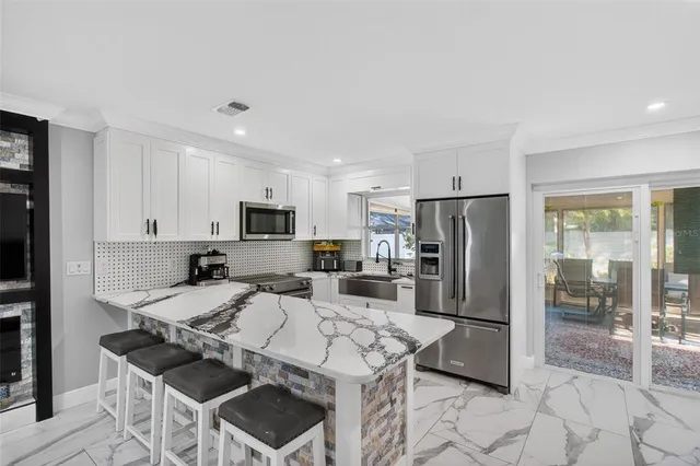 a kitchen with stainless steel appliances granite countertop a refrigerator stove microwave and sink