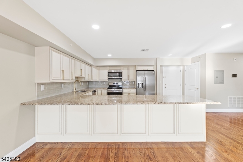 658 Market Street Paterson, NJ 07513 - Photo 15 of 19 a large white kitchen with kitchen island sink and refrigerator