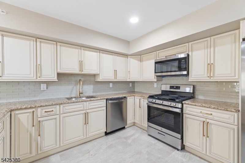 658 Market Street Paterson, NJ 07513 - Photo 17 of 19 a kitchen with white cabinets stainless steel appliances and sink