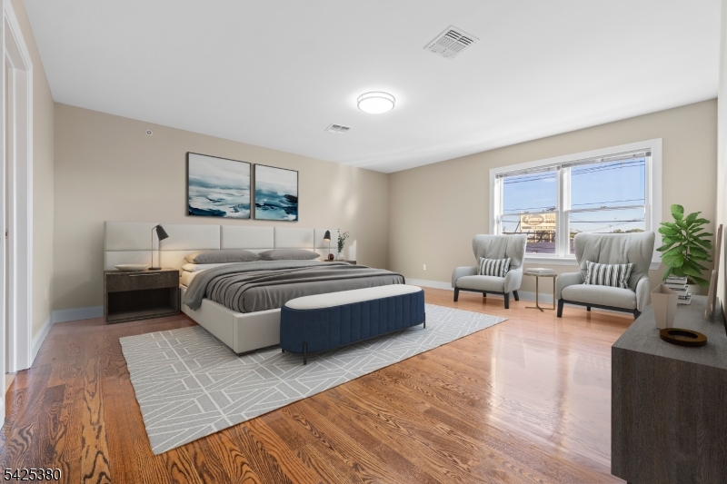 658 Market Street Paterson, NJ 07513 - Photo 4 of 19 a spacious bedroom with a bed a couch and potted plant on the dresser