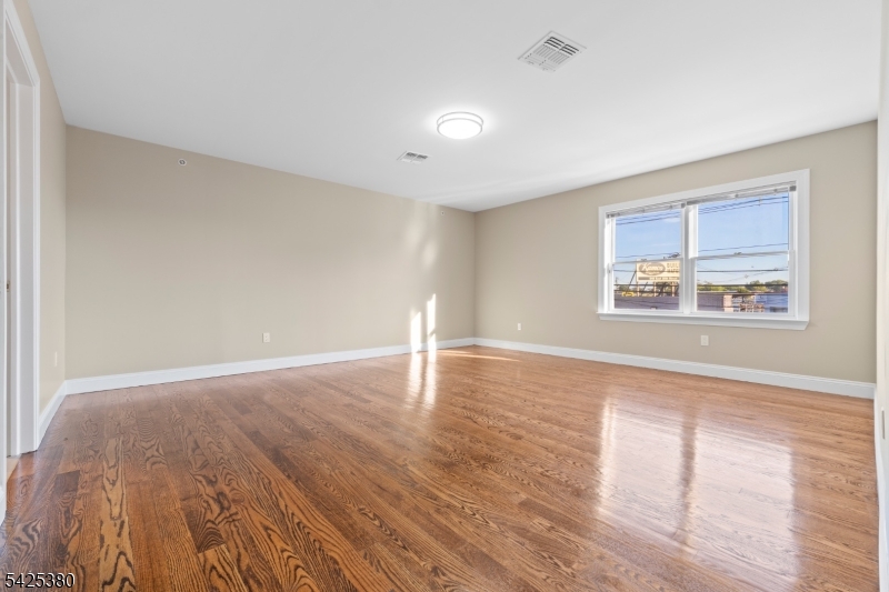 658 Market Street Paterson, NJ 07513 - Photo 5 of 19 a view of empty room with wooden floor and fan