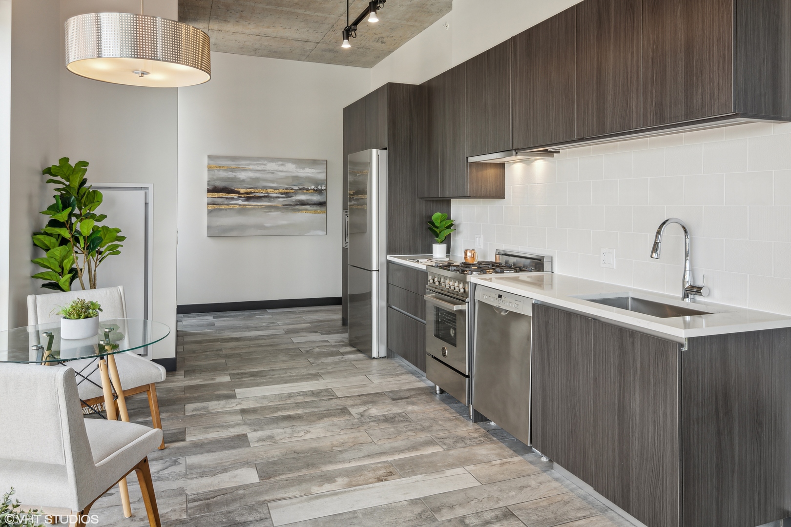 171 North Aberdeen Street, Unit 804 Chicago, IL 60607 - Photo 5 of 23 a kitchen with stainless steel appliances a sink a stove top oven a counter space and cabinets