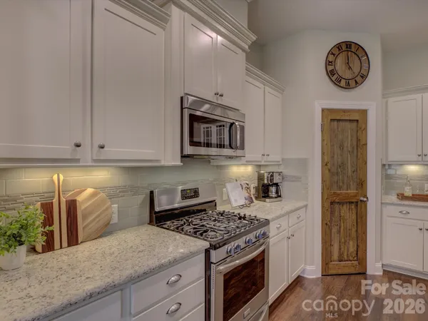 a kitchen with stainless steel appliances granite countertop a stove a microwave and cabinets