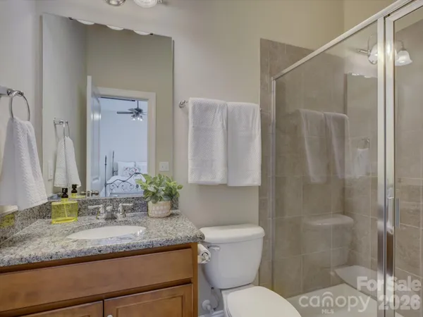 a bathroom with a granite countertop sink a toilet and shower