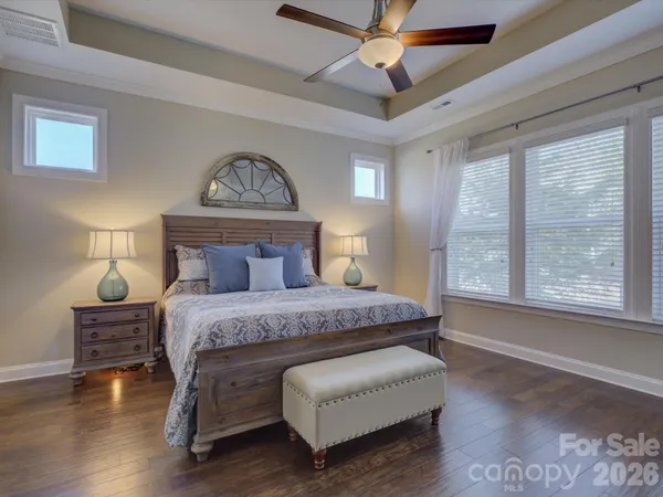 a bedroom with a bed a chandelier and a window