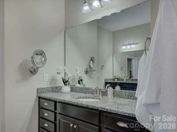 a bathroom with a granite countertop sink a mirror and vanity