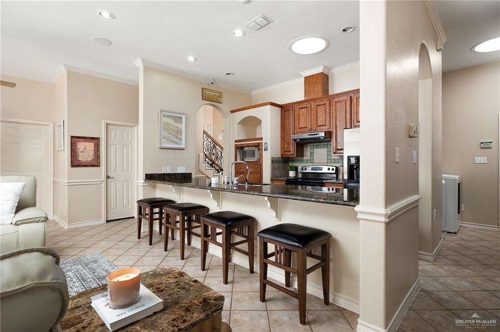 818 Hill Country Road Edinburg, TX 78539 - Photo 7 of 24 a kitchen with stainless steel appliances granite countertop a refrigerator and a stove top oven