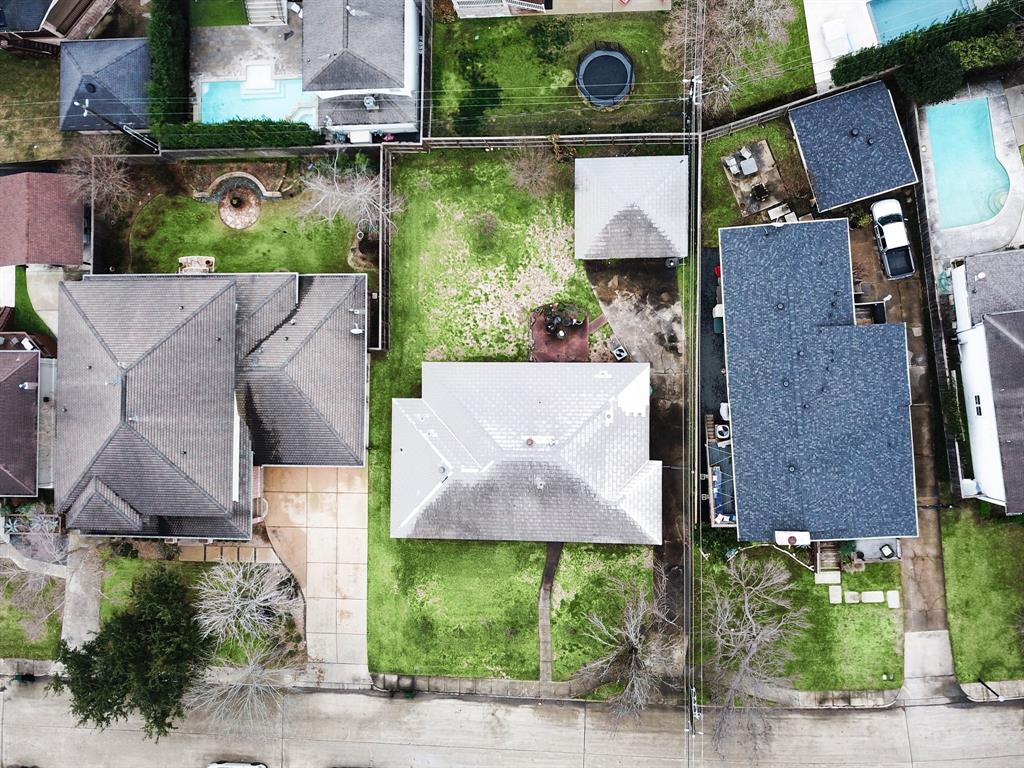 an aerial view of a house with a yard and a car park