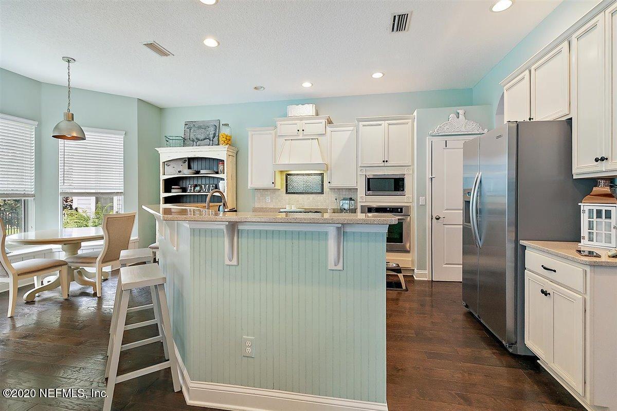 40 Pelican Pointe Road Ponte Vedra, FL 32081 - Photo 13 of 45 a kitchen with stainless steel appliances granite countertop a refrigerator a stove a sink a dining table and chairs with wooden floor