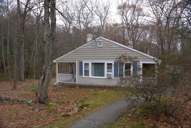 a front view of a house with a yard and trees