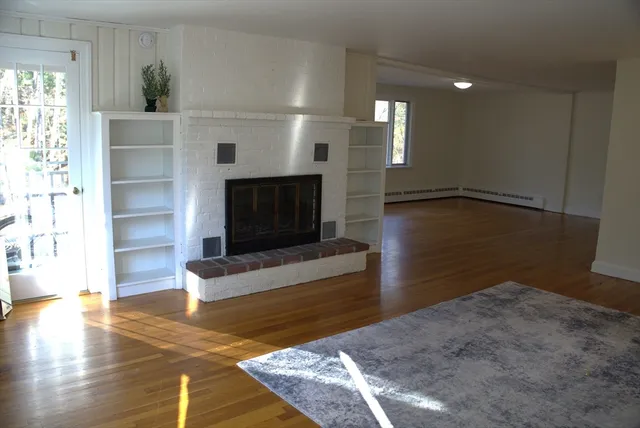 a living room with hard wood floors and a fireplace