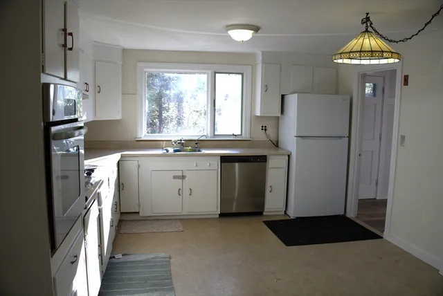 a kitchen with a refrigerator a sink and cabinets