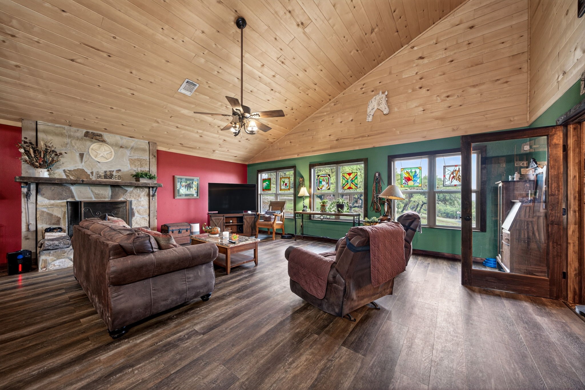 1850 Ranch Road 337 Leakey, TX 78873 - Photo 31 of 50 Spacious living area featuring updated flooring and a wood-burning fireplace for cozy Hill Country evenings