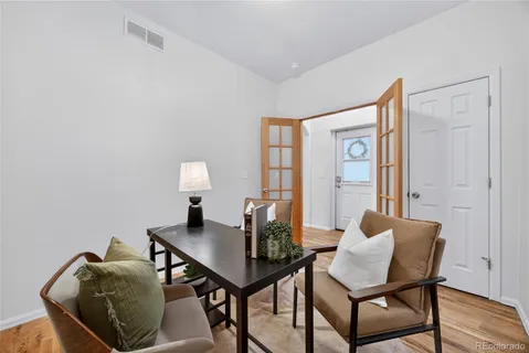 a view of a workspace with furniture and wooden floor