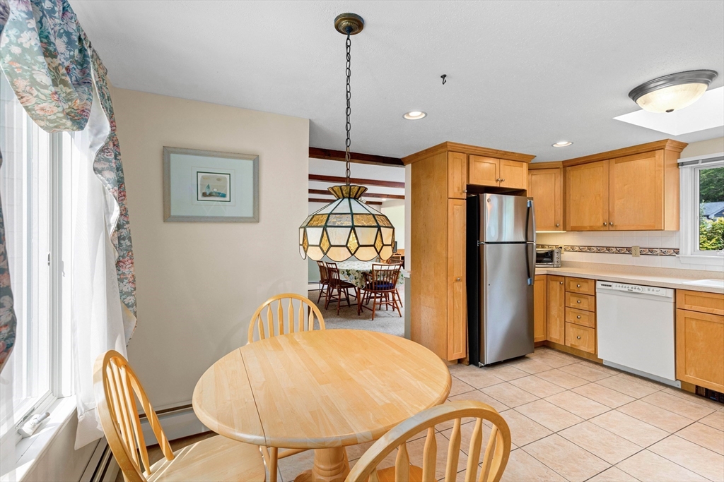 140 Rolling Hitch Road Barnstable, MA 02632 - Photo 9 of 36 a kitchen with stainless steel appliances granite countertop a refrigerator a stove a sink dishwasher with a dining table and chairs