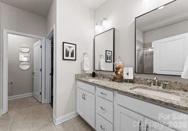 a bathroom with a granite countertop sink two mirror and a