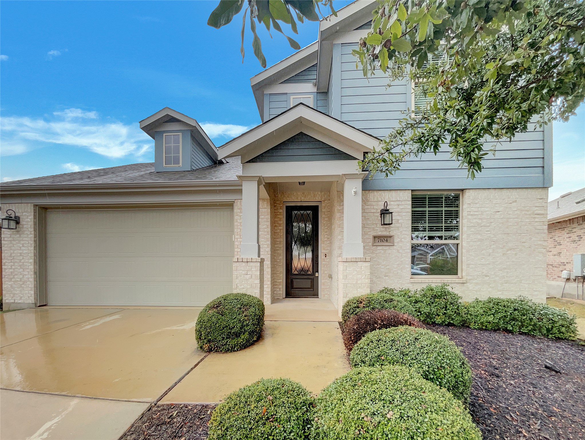 7104 Brick Slope Path Austin, TX 78744 - Photo 1 of 1 View of front facade with brick siding, driveway, and an attached garage