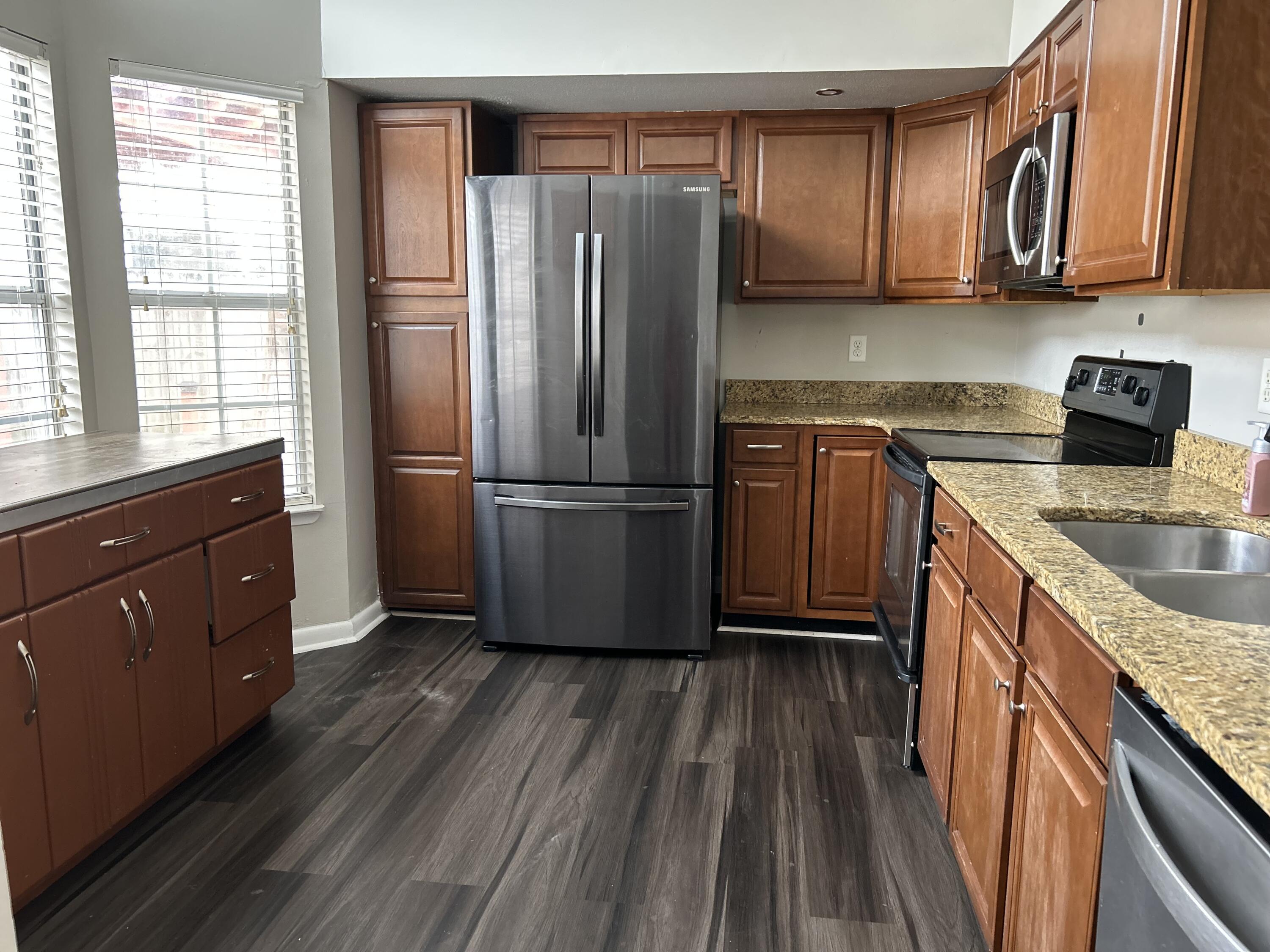 404 Adam Street Northwest Fort Walton Beach, FL 32548 - Photo 4 of 11 a kitchen with granite countertop wooden floors stainless steel appliances a sink and a window
