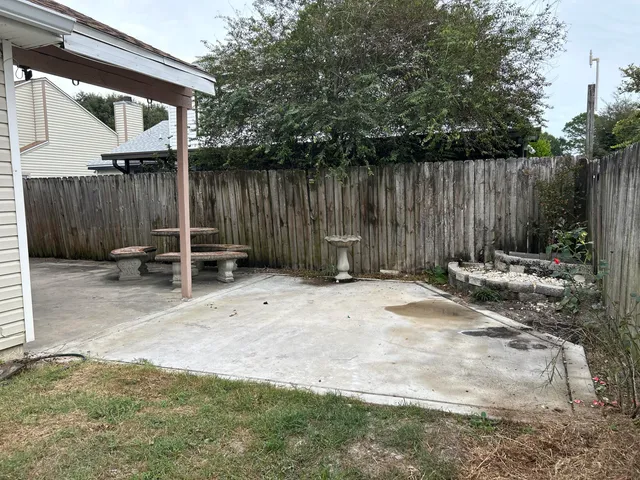 a backyard of a house with chairs and a table