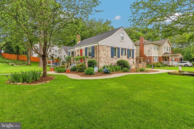 a front view of a residential houses with yard and green space